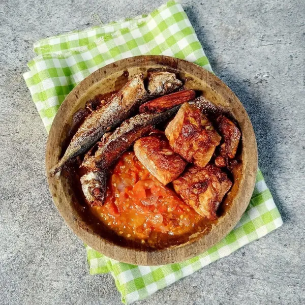 Sajikan mandai dan ikan lajang goreng dengan sambal tomat.