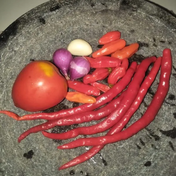 Haluskan bawang merah, bawang putih, cabe rawit, cabe keriting dan tomat.