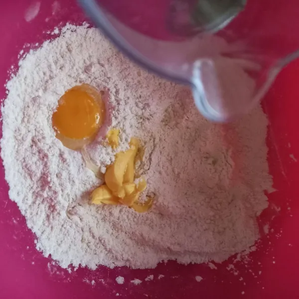Masukkan mentega dan telur, kemudian masukkan sedikit demi sedikit air sambil diaduk hingga kalis.