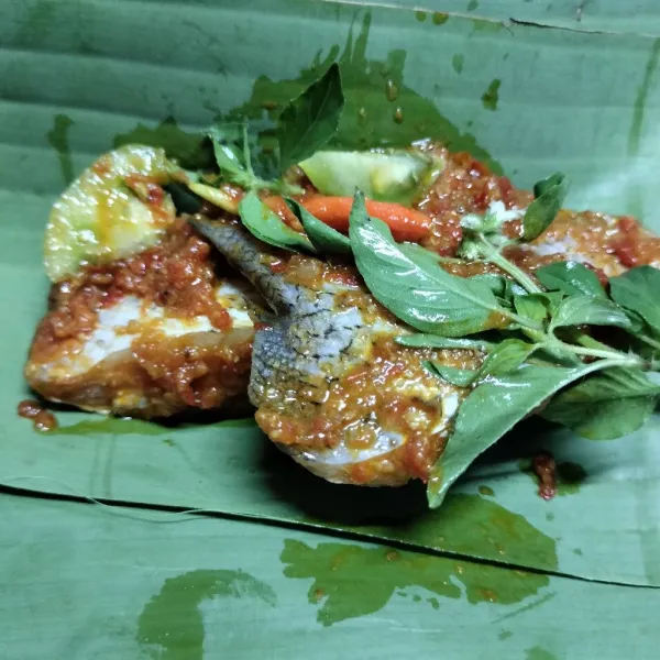 Kemudian bungkus pepes dengan daun pisang tambahkan daun kemangi dan tomat hijau lalu bungkus.