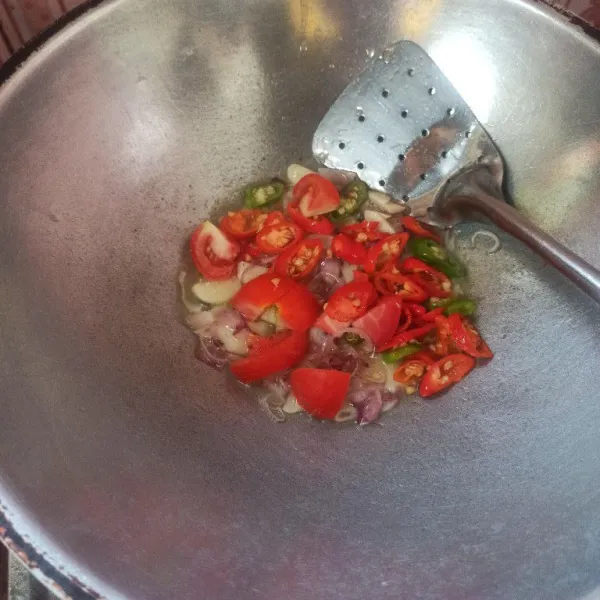 Selanjutnya masukkan cabai rawit dan tomat tumis sampai layu.