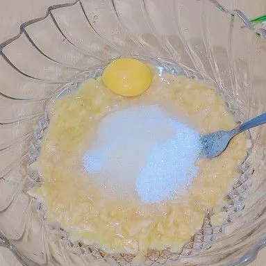 Dalam wadah yang sama tambahkan gula dan telur ayam lalu aduk hingga gula larut.