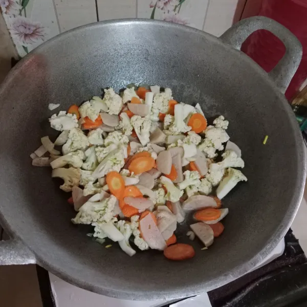 Masukkan irisan wortel, kembang kol, dan bakso. Beri secukupnya air masak hingga lunak.