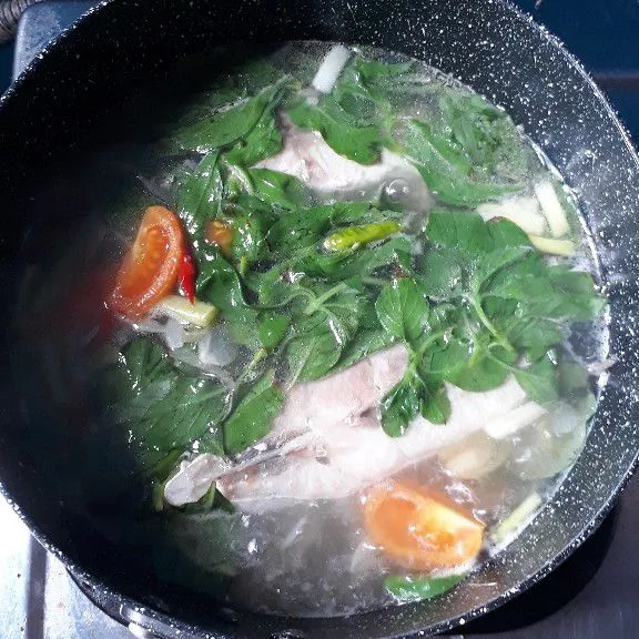 Selanjutnya masukan ikan. Masak sampai ikan empuk. Lanjut masukan daun kemangi dan tomat. Aduk sampai kemangi dan tomat layu.