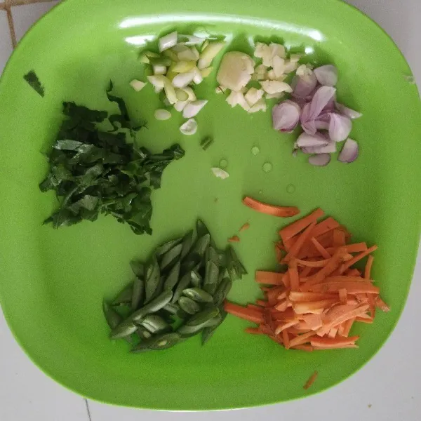 Iris-iris bawang merah, bawang putih, daun bawang, seledri, buncis dan wortel.