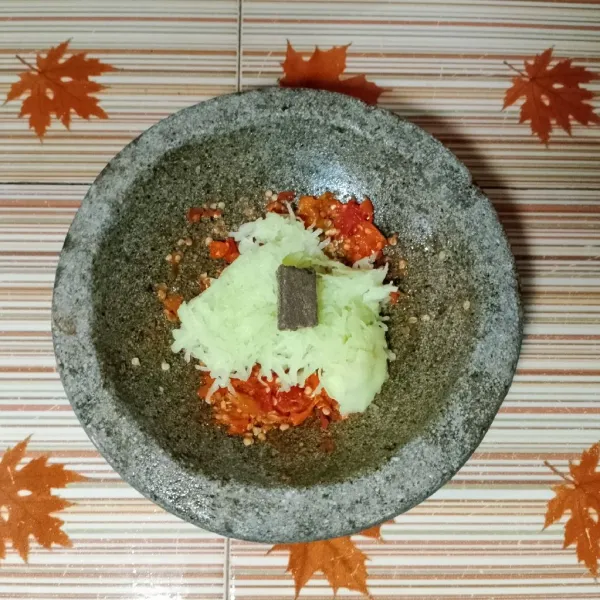 Tambahkan terasi bakar, kemudian uleg hingga tercampur rata dan sedikit halus.