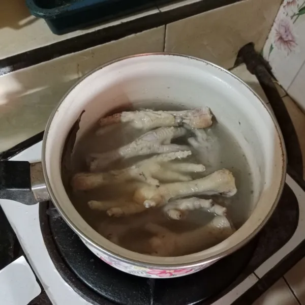 Rebus ceker buang air pada rebusan pertama, kemudian rebus lagi hingga empuk. Ambil segelas kaldunya untuk memasak.