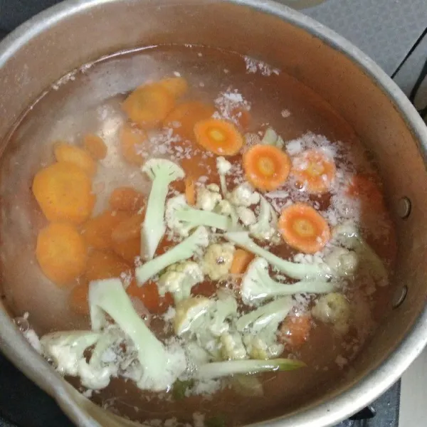 Masukkan potongan wortel dan kembang kol. Masak sampai setengah matang, masukkan bakso dan kecambah. Tambahkan kaldu bubuk.