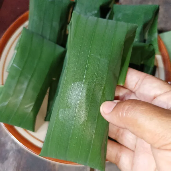 Bungkus adonan dengan daun pisang.