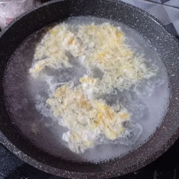 Didihkan air, kocok lepas telur lalu masukkan telur dan aduk-aduk perlahan.