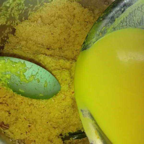 Tuang bumbu nasi kuning ke dalam nasi aron tadi, tuang perlahan kemudian diamkan 30 menit.