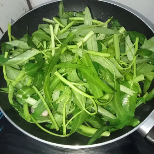 Masukkan kangkung ke dalam wajan.