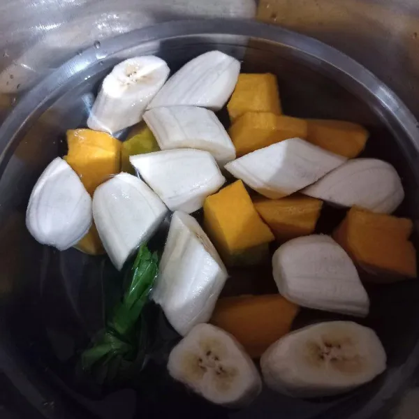 Didihkan air, rebus pisang, labu dan pandan hingga pisang dan labu 3/4 matang.