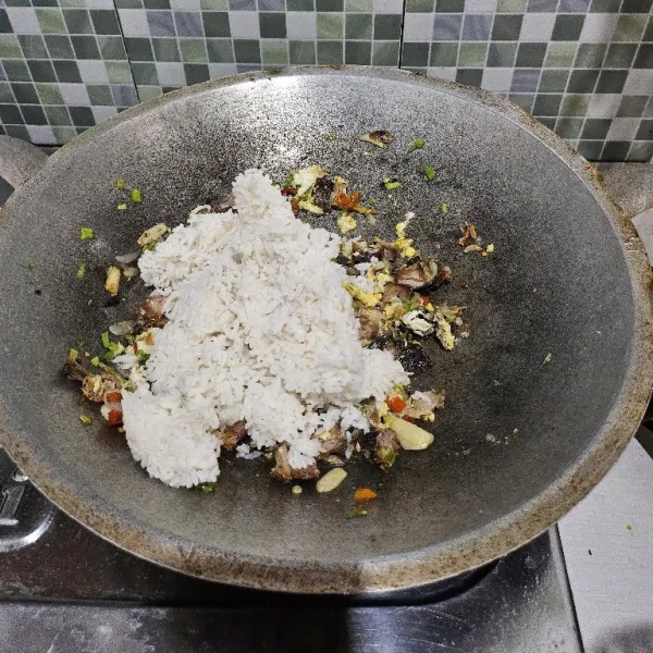 Setelah itu masukkan nasi putih. Aduk cepat hingga merata.