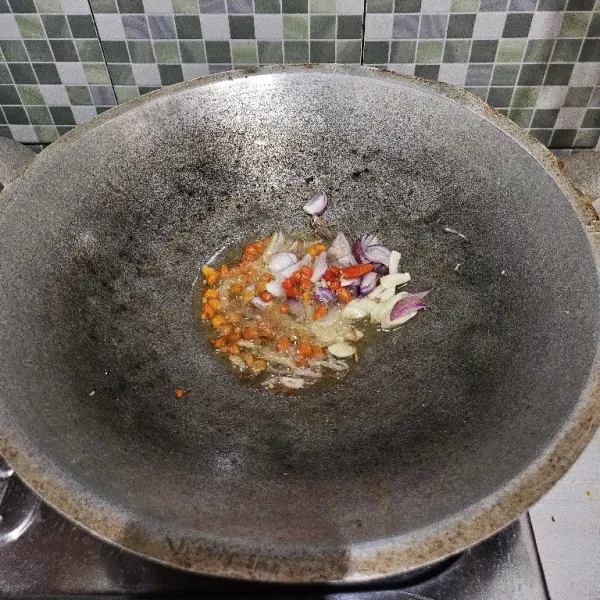 Tumis bawang merah, bawang putih, serta cabe rawit hingga harum dan layu.