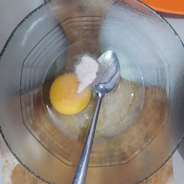 Pecahkan telur dalam mangkuk. Bumbui dengan bawang putih bubuk, garam, kaldu jamur dan lada bubuk. Kocok lepas.