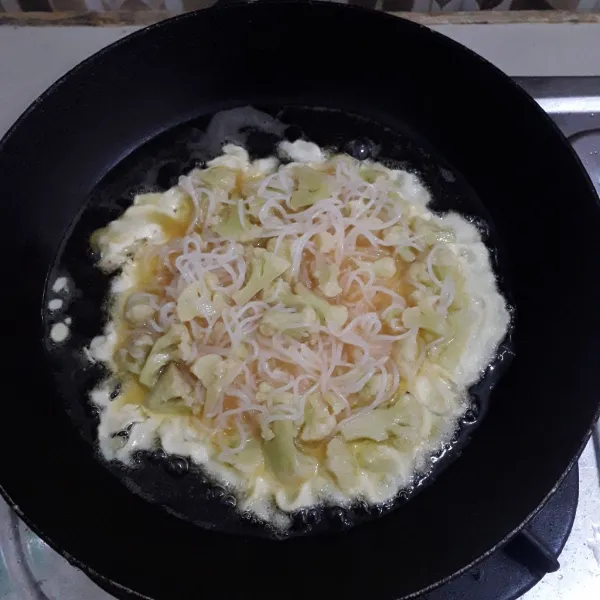 Goreng telur dalam minyak panas. Balik jika bagian bawah sudah kecokelatan, goreng hingga matang di kedua sisinya.