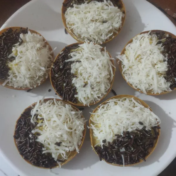 Selagi masih panas, oles dengan margarin, beri toping coklat, keju parut, dan susu kental manis.
