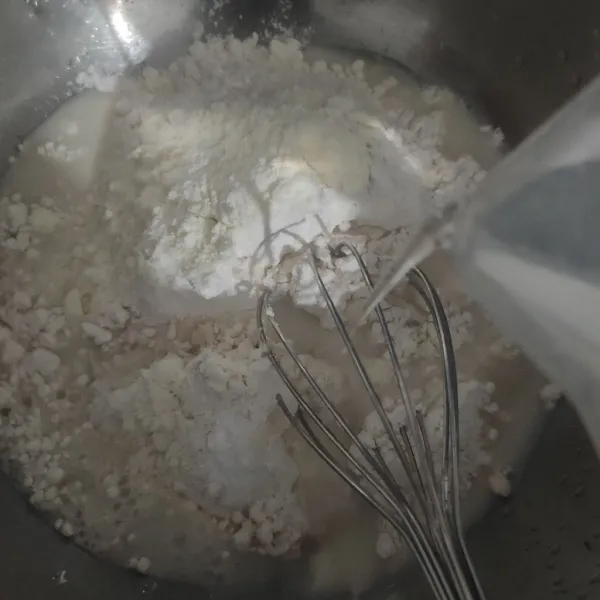 Campur tepung terigu, susu bubuk, gula halus, vanili, dan garam. Tuang air sedikit demi sedikit aduk rata.
