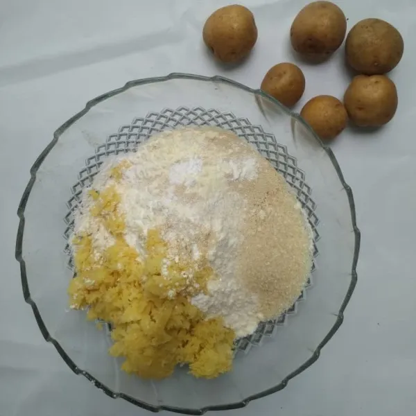Dalam bowl campur tepung, kentang kukus yang sudah di haluskan gula, dan susu bubuk uleni hingga tercampur rata .