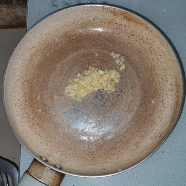 Letakkan teflon ke atas kompor, panaskan minyak zaitun, masukkan bawang putih. Goreng hingga layu, kemudian sisihkan.