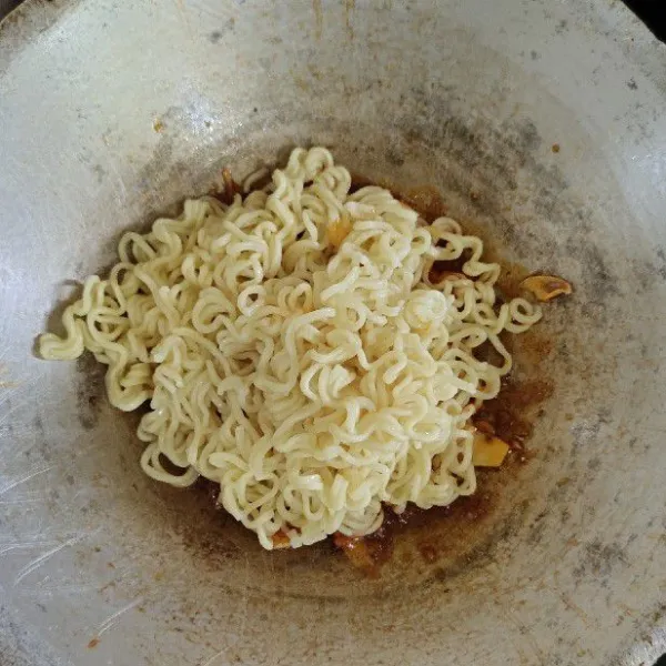 Masukkan mie setengah matang, aduk rata.