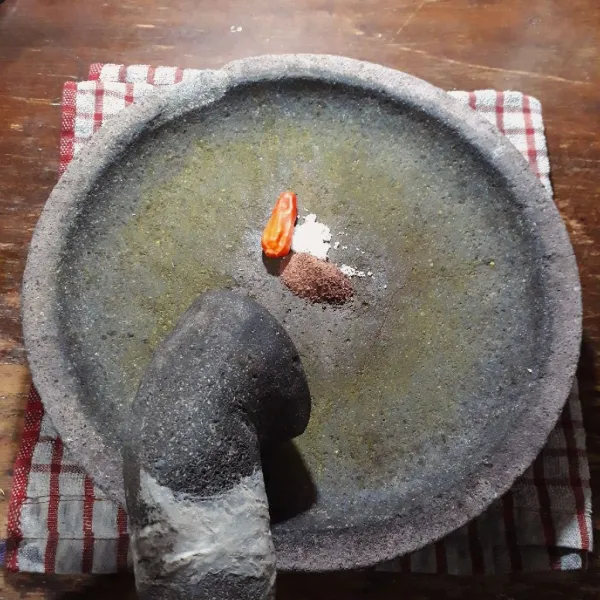 Haluskan cabe, garam dan terasi.