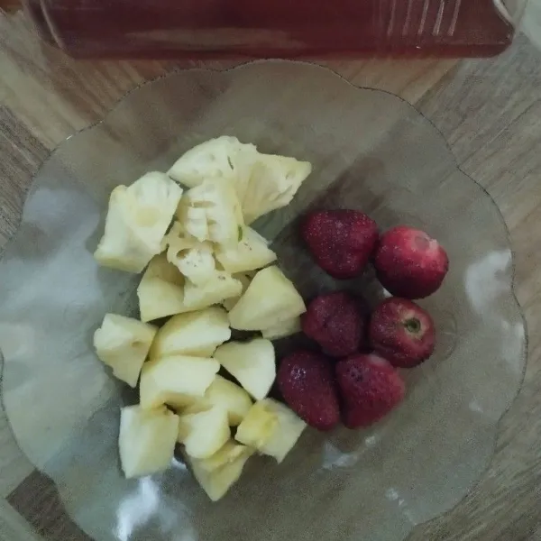 Potong buah nanas, apel dan strawberry.