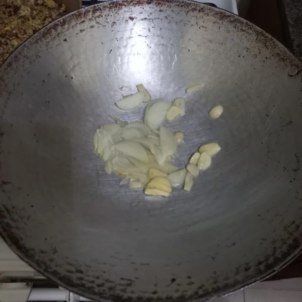 Tumis irisan bawang bombai dan bawang putih hingga harum.