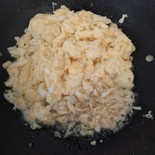 Sisihkan telur di tepi wajan, masukkan bawang putih cincang lalu tumis hingga harum.