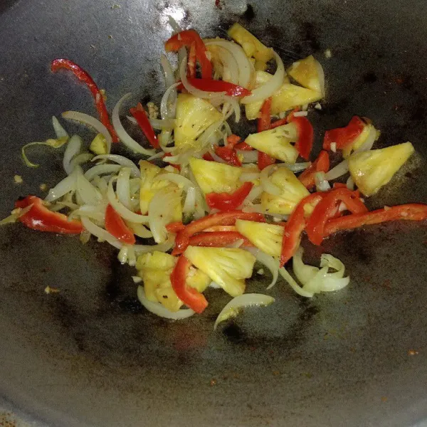 Tumis bawang putih dan bawang bombay hingga sedikit layu, kemudian masukkan paprika dan nanas tumis sebentar.