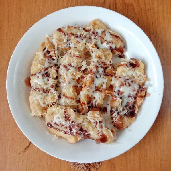 Selagi pisang panas beri topping kental manis coklat dan parutan keju mozarella. Pisang goreng siap dinikmati.