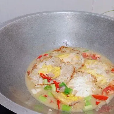 Masukkan tomat, daun bawang, pete, ikan teri dan telur ayam lalu masak hingga kuah menyusut. Koreksi rasa telor ceplok masak kuah siap disajikan.