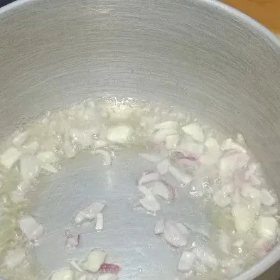 Panaskan minyak goreng lalu goreng bawang merah dan bawang putih hingga harum.