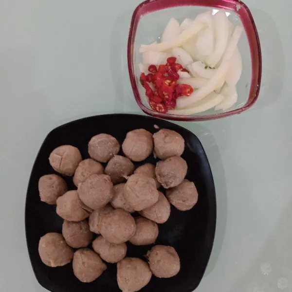 Potong bawang bombay, cabai keriting, dan bakso. Potongan bakso bisa disesuaikan sesuai dengan selera.