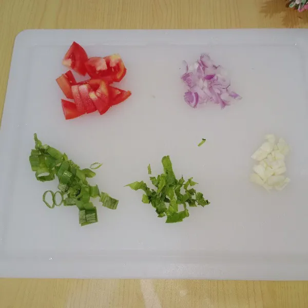 Diiris tipis bawang merah, bawang putih, tomat merah, seledri dan daun bawang.