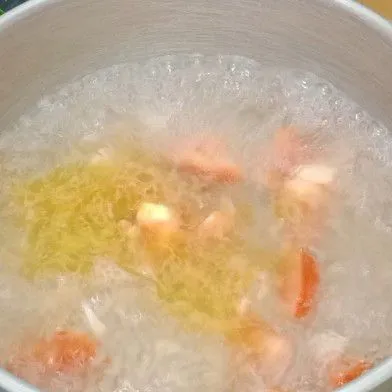 Masukkan air bersih dan tomat merah kemudian masak hingga mendidih.