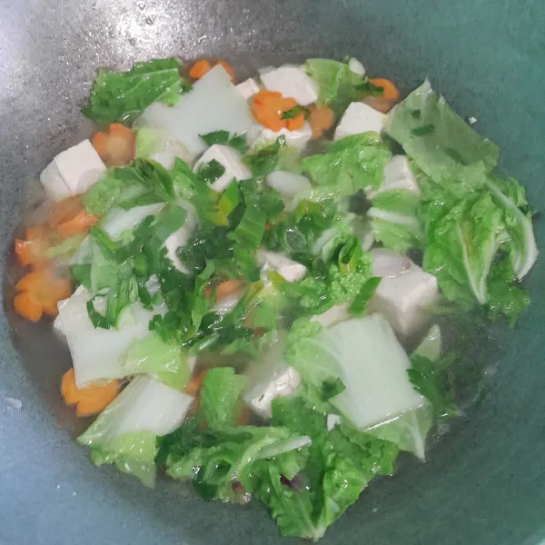 Masukkan sawi, daun bawang, dan daun seledri, lalu masak sampai sayuran empuk, siap disajikan