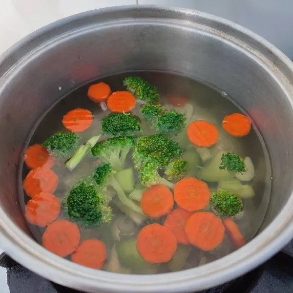 Ketika wortel kelihatan transparan, masukkan potongan brokoli. Rebus hingga keduanya empuk.