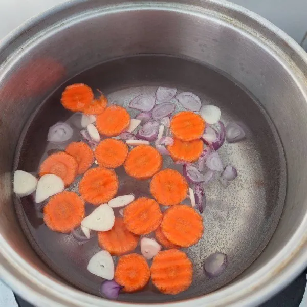 Rebus irisan bawang merah, bawang putih, wortel dan 500 ml air hingga wortel empuk.
