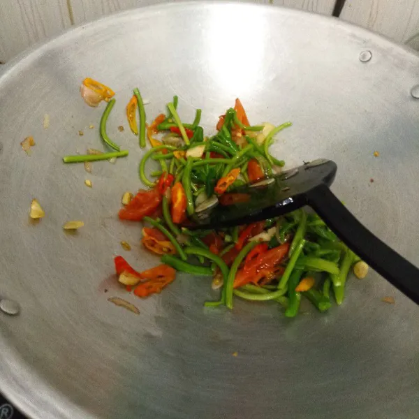 Masukkan tangkai bayam dan tumis sampai layu