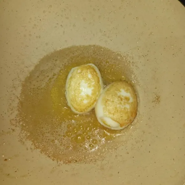 Panaskan minyak dan goreng telur hingga berkulit
