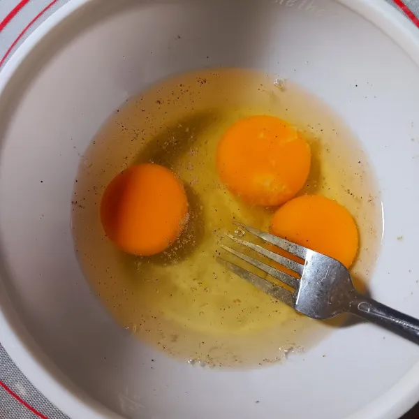 Pecahkan telur, bumbui garam dan lada, kocok lepas.
