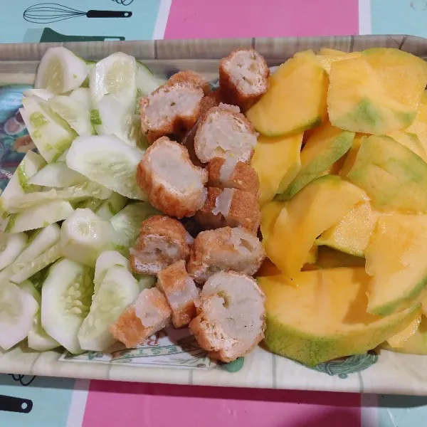 Iris tipis buah-buahan, tahu dan tata di piring saji. Sajikan bersama bumbu rujak manis.