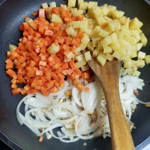 Membuat saus kari : tumis bawang putih dan bombay hingga harum, masukkan potongan kentang dan wortel.  Masak hingga layu kemudian tambahkan air dan pasta kari.