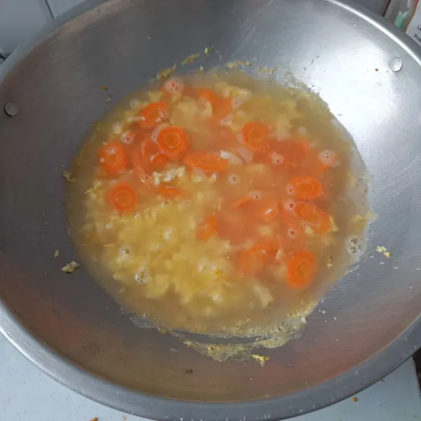 Tambahkan air hingga terendam, masak hingga wortel setengah matang atau air menyusut setengahnya.