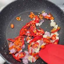 Panaskan minyak, tumis bawang merah dan bawang putih hingga harum, tambahkan irisan cabe rawit dan cabe merah besar. Tumis kembali hingga layu dan matang.
