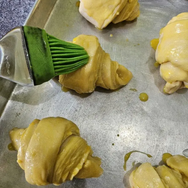 Tata di loyang, diamkan selama 30 menit. Oles dengan kuning telur, lalu panggang di oven dengan suhu 200°C selama 15-20 menit hingga matang.
