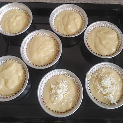 Siapkan kertas cup, tuang adonan sebanyak 2/4 lalu beri toping keju parut. Panggang selama 15 menit dengan suhu oven 170°c menggunakan api atas bawah.