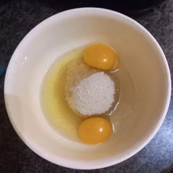 Dalam wadah tuang gula pasir dan telur ayam, mixer hingga putih mengembang.